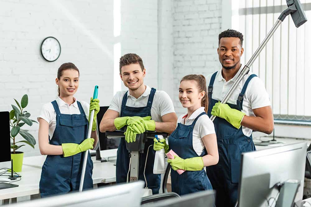 Commercial Cleaners in Jackson MS Posing For Picture While Cleaning Office Business Office Space - Facility Solution Services - Best Commercial Cleaning Services Jackson MS